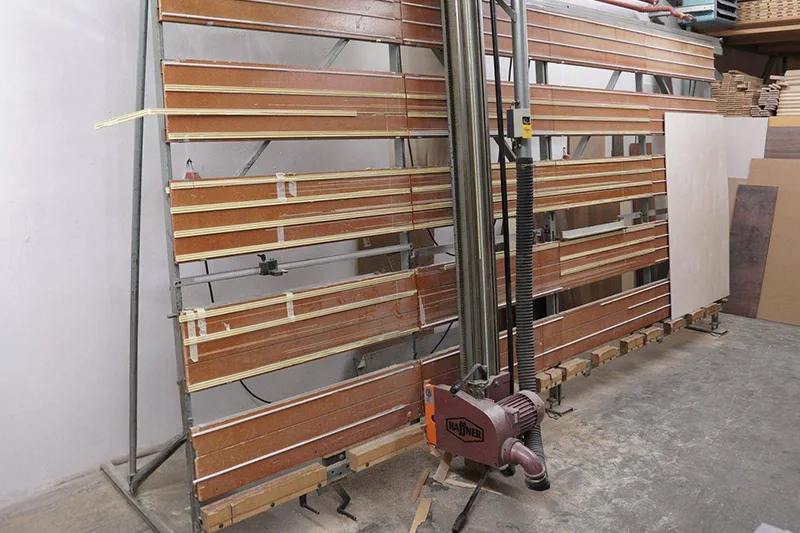 Scie à panneaux verticale HAFFNER utilisée dans des ateliers de menuiserie pour des découpes précises et efficaces sur des matériaux de grande taille.
